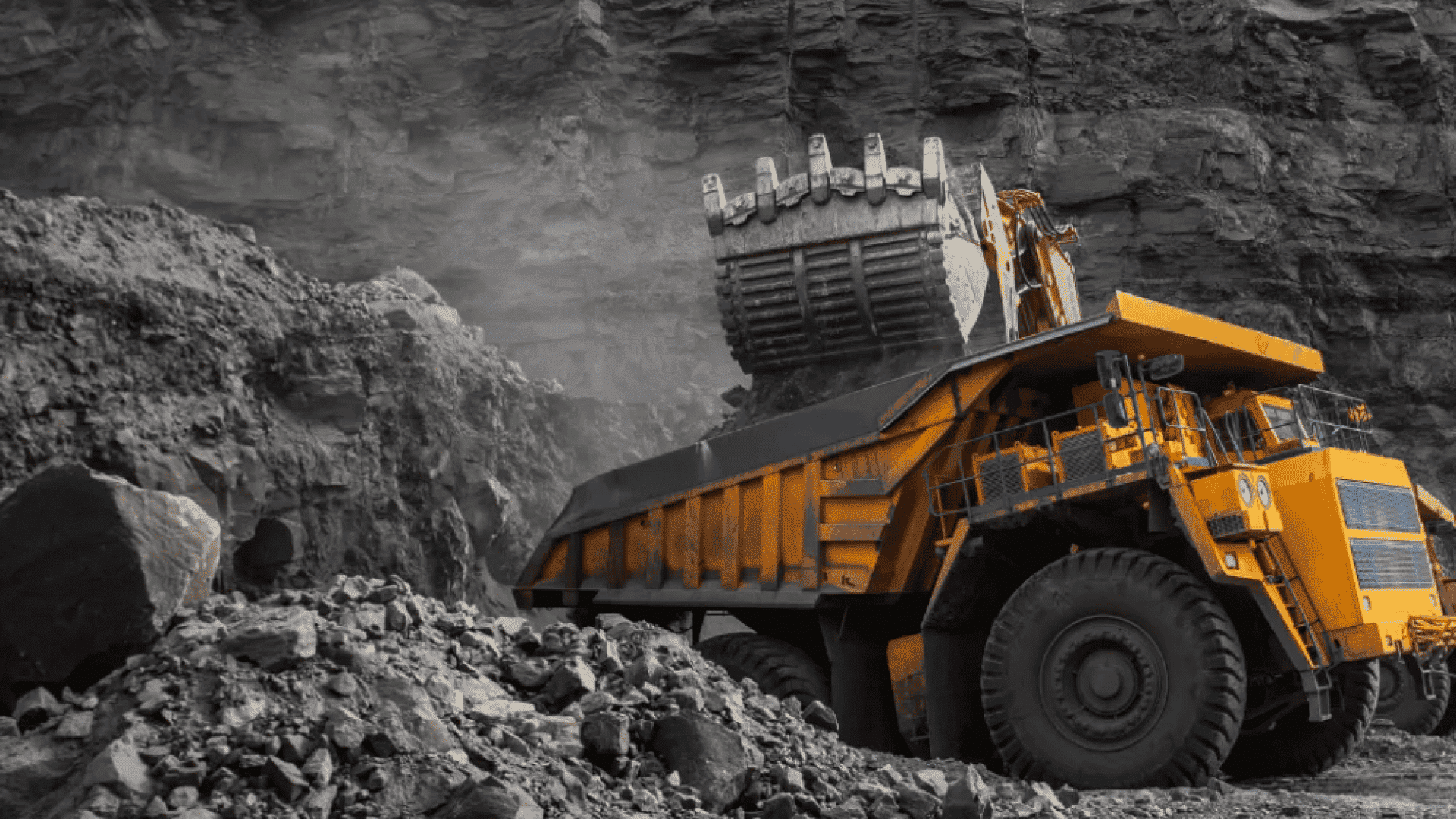Large mining excavator loading a haul truck at an open-pit mine—an essential application for electrically insulated bearings to prevent electrical erosion.