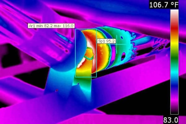 Infrared thermal camera screen showing a high-temperature hot spot on a motor bearing.